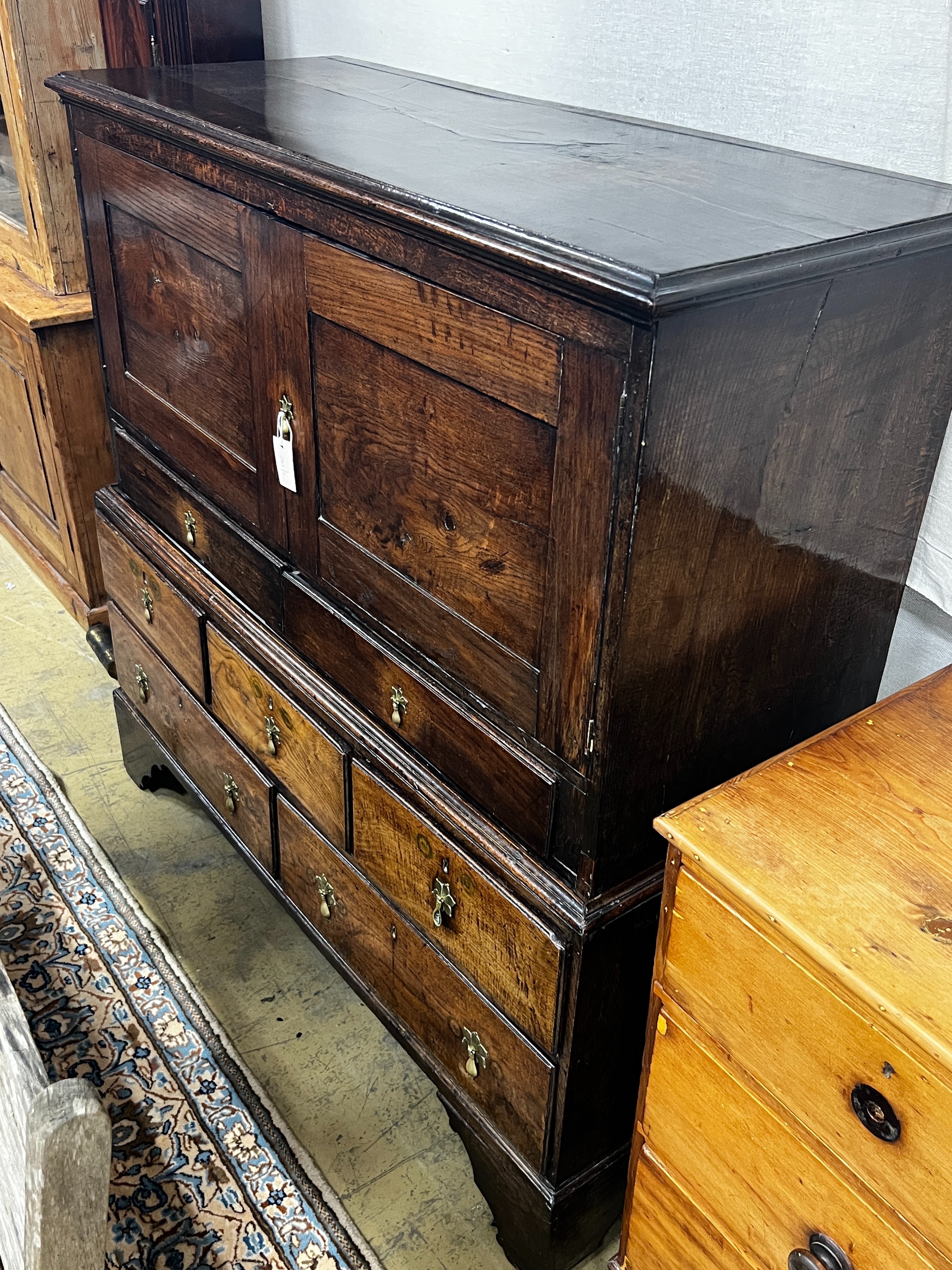 An 18th century oak low press cupboard, length 136cm, depth 53cm, height 137cm